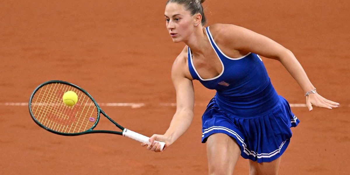 Tenisistka Marta Kostiuk uderza piłkę rakietą podczas meczu na kortach ziemnych.